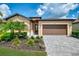 Attractive single-story home with a tan stucco exterior, two-car garage and landscaped yard at 1836 W Isles Rd, Port Charlotte, FL 33953