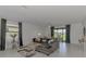 Bright living room featuring tile flooring, a plush sofa, modern decor and a dining area at 1836 W Isles Rd, Port Charlotte, FL 33953