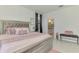 Main bedroom with an elegant bed, soft pink accents, and a glimpse into the ensuite bathroom at 1836 W Isles Rd, Port Charlotte, FL 33953