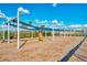 Community playground showcasing swings under a trellis offering partial shade at 1836 W Isles Rd, Port Charlotte, FL 33953