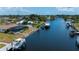 A waterfront home featuring a private dock and boats, with beautiful blue water views and mature trees at 18451 Goodman Cir, Port Charlotte, FL 33948