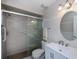 Well-lit bathroom featuring tiled shower, vanity with storage, and a round mirror for a clean aesthetic at 18451 Goodman Cir, Port Charlotte, FL 33948