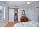 Cozy bedroom with natural light, featuring a barn-door, closet, and dresser with a mounted television at 18451 Goodman Cir, Port Charlotte, FL 33948