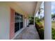 Charming front porch with stone flooring, colorful shutters, and lush landscaping at 18451 Goodman Cir, Port Charlotte, FL 33948