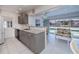 Well-lit kitchen showcasing stone countertops, tiled floors, modern appliances, and a serene pool view at 18451 Goodman Cir, Port Charlotte, FL 33948