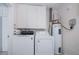 Efficient laundry room with washer, dryer, water heater, and storage cabinets for convenience at 18451 Goodman Cir, Port Charlotte, FL 33948