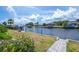 Picturesque waterfront view with a well-maintained seawall and lush landscaping at 18451 Goodman Cir, Port Charlotte, FL 33948