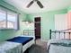 Bedroom featuring two beds, a ceiling fan, and an open closet for optimal storage solutions at 18790 Countryman Ave, Port Charlotte, FL 33948