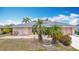 A lovely single-story home with a two-car garage, complemented by palm trees and low-maintenance landscaping at 18790 Countryman Ave, Port Charlotte, FL 33948