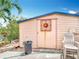 Outdoor shed with a sun ornament door in the backyard offers extra storage space at 18790 Countryman Ave, Port Charlotte, FL 33948