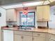 Kitchen sink and counter area highlighting the red pendant lights, and window view of the pool at 18790 Countryman Ave, Port Charlotte, FL 33948
