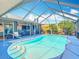 Sparkling pool is the centerpiece of this screened-in lanai with ample seating at 18790 Countryman Ave, Port Charlotte, FL 33948
