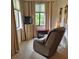 Comfortable bedroom with recliner chair sitting beneath two well lit windows at 19 Medalist Way, Rotonda West, FL 33947