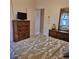 Bright bedroom with a patterned bedspread, chest of drawers, and a view of the hallway at 19 Medalist Way, Rotonda West, FL 33947