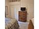Traditional bedroom boasts wood dresser, plush carpet, and neutral color scheme at 19 Medalist Way, Rotonda West, FL 33947