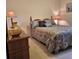 This carpeted bedroom includes lamps on both sides of the bed and artwork at 19 Medalist Way, Rotonda West, FL 33947