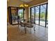 Bright dining room with large glass doors to an outdoor pool and patio at 19 Medalist Way, Rotonda West, FL 33947