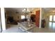 Open concept dining room featuring a glass-top table and chairs, connecting to a kitchen and living area at 19 Medalist Way, Rotonda West, FL 33947