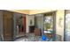 View of a lanai area with a glass-top table set and the interior of the home beyond at 19 Medalist Way, Rotonda West, FL 33947