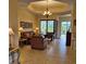 Comfortable living room with tile flooring, leather furniture, and sliding glass doors at 19 Medalist Way, Rotonda West, FL 33947
