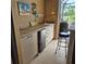 Outdoor kitchen features ample counter space, cabinetry, mini fridge and grill at 19 Medalist Way, Rotonda West, FL 33947