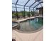 Sparkling screened-in pool and spa with beautiful views of the landscaped backyard and canal at 19 Medalist Way, Rotonda West, FL 33947