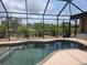 Lovely screened-in pool with stunning views of the landscaped backyard and waterway at 19 Medalist Way, Rotonda West, FL 33947