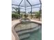 Relaxing screened-in pool and spa area with a charming alligator statue and sunny backyard views at 19 Medalist Way, Rotonda West, FL 33947