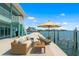 Backyard deck area with comfortable seating, an umbrella and a boat lift with a beautiful waterfront view at 1900 Illinois Ave, Englewood, FL 34224