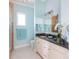 Bathroom features a granite counter, shower with a window and blue decor at 1900 Illinois Ave, Englewood, FL 34224