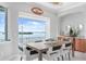 Elegant dining room with a large window offering scenic waterfront views and stylish furnishings at 1900 Illinois Ave, Englewood, FL 34224