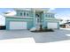 Stunning two-story blue house with a well-manicured lawn and a paved driveway leading to a two-car garage at 1900 Illinois Ave, Englewood, FL 34224