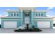 Beautiful turquoise two-story home featuring a double garage, columns, and well-manicured landscaping at 1900 Illinois Ave, Englewood, FL 34224