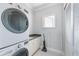 Well-lit laundry room featuring a stackable washer and dryer and storage with a drying rack and granite countertops at 1900 Illinois Ave, Englewood, FL 34224