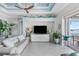 Bright living room featuring a white sofa, large TV, and sliding doors to the balcony at 1900 Illinois Ave, Englewood, FL 34224