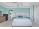 Bright main bedroom with tray ceiling, ceiling fan, coastal decor and ensuite bathroom at 1900 Illinois Ave, Englewood, FL 34224
