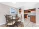 Dining area leads to kitchen with white appliances and ample wooden cabinets at 1965 Louisiana Ave, Englewood, FL 34224