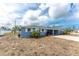 A well-maintained exterior featuring a vibrant color, lush greenery, and a convenient carport at 1965 Louisiana Ave, Englewood, FL 34224