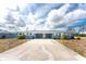 Charming duplex featuring a shared driveway, beautiful landscaping, and a classic design with a light-blue exterior at 1965 Louisiana Ave, Englewood, FL 34224