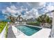 Inviting community pool with lounge chairs and lush palm trees, great for summertime fun at 1965 Louisiana Ave, Englewood, FL 34224