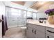 Bathroom with glass-enclosed shower, vanity, and tiled floor, featuring purple flower decor at 2125 Floribanna St, North Port, FL 34287