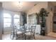 Dining room with chandelier, glass table with seating for six, and natural light from arched windows at 2125 Floribanna St, North Port, FL 34287