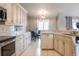 Bright and airy kitchen with white cabinetry, a dishwasher, and an adjacent dining area at 2125 Floribanna St, North Port, FL 34287