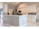 Well-lit kitchen featuring white cabinetry, stainless steel appliances, and a breakfast bar overlooking the living area at 2125 Floribanna St, North Port, FL 34287