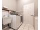 Functional laundry room equipped with a sink, storage shelf, and a modern washer and dryer at 2125 Floribanna St, North Port, FL 34287