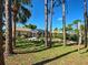 Large, private backyard featuring tropical trees, a screened-in patio, and a gravel path at 237 Rotonda E Blvd, Rotonda West, FL 33947