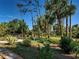 Lush backyard featuring a gravel path, tropical plants and trees, and a charming blue bench at 237 Rotonda E Blvd, Rotonda West, FL 33947