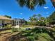 Sprawling backyard featuring the home's screened-in patio, a gravel path and established landscaping at 237 Rotonda E Blvd, Rotonda West, FL 33947