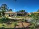 Spacious backyard with a screened-in patio, lovely landscaping and winding gravel path at 237 Rotonda E Blvd, Rotonda West, FL 33947