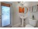 Powder room with a pedestal sink, decorative mirror, and unique glass door at 237 Rotonda E Blvd, Rotonda West, FL 33947